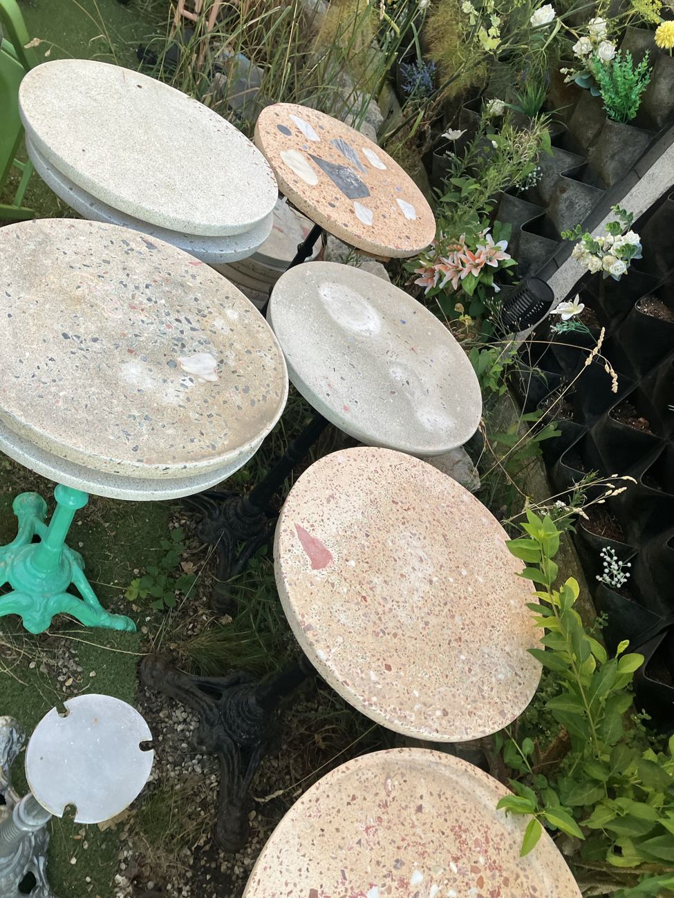 Plateaux de terrazzo aux teintes sable, rouge et gris dans le jardin