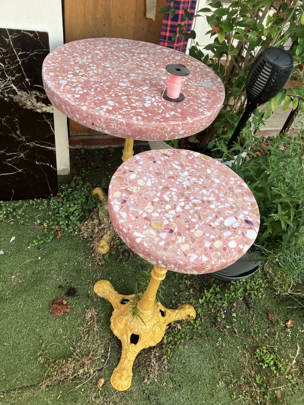 Deux plateaux rose et blanc en terrazzo sur pieds jaunes