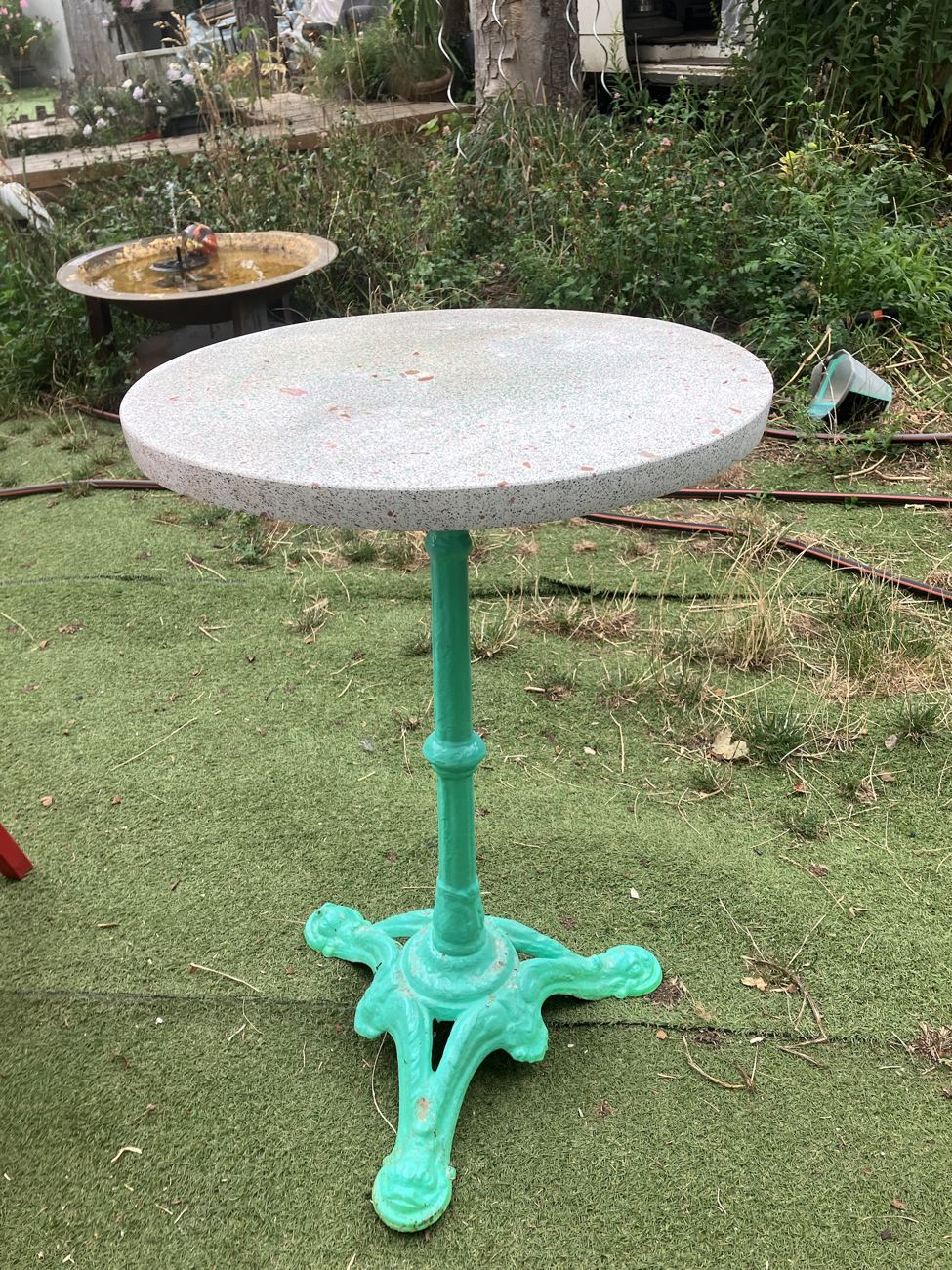 Table en terrazzo Terre, plateau clair sur pied vert vif, vue de profil